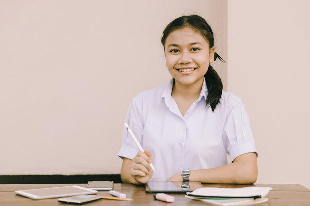 亚洲泰国可爱的女孩少年学生校服快乐的微笑使用平板电脑E-Learning自我隔离教育快乐的微笑概念图片下载