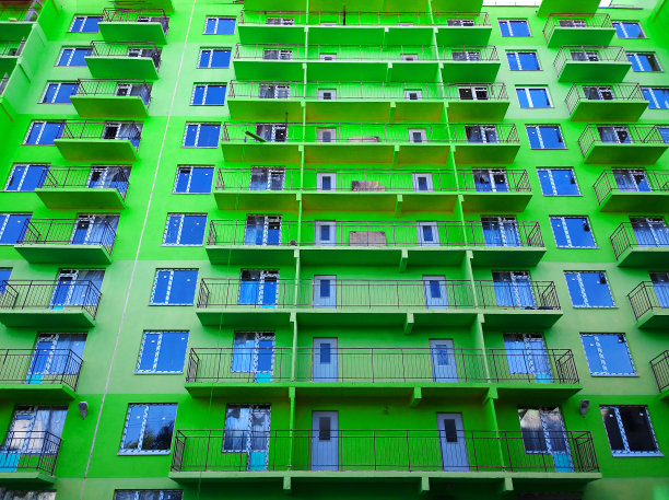 新绿色住宅建筑立面。销售和出租经济舱公寓和舒适住房。城市景观。窗户和阳台。城市生活。房地产。抵押贷款的概念。房子图片下载