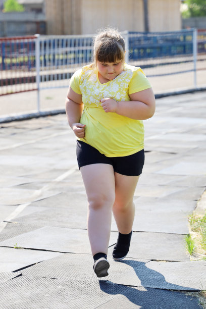 胖女孩穿着运动服在马路上跑步图片下载