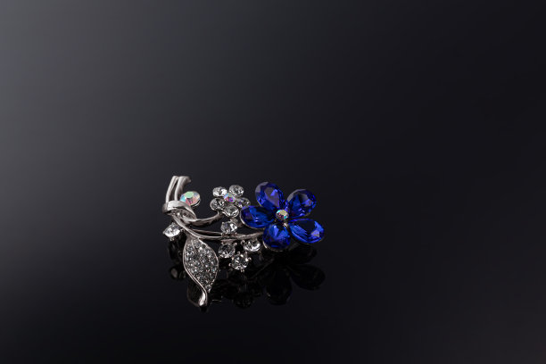 宝石和珠宝在黑暗的背景上。胸针、发夹、耳环和吊坠。图片下载