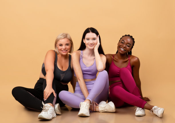 肖像的三个不同的微笑多民族女士摆姿势在运动服图片下载