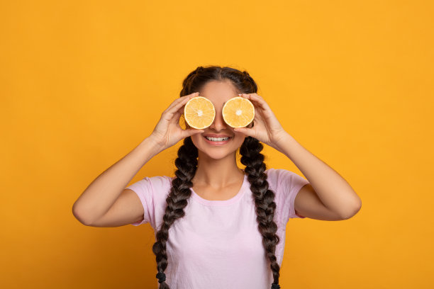 印度女子用半片柑橘类的橙子遮住眼睛图片下载