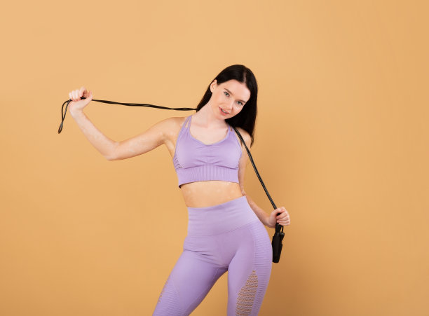 运动的生活方式。年轻健康的女人与白癜风皮肤摆姿势与跳绳图片下载