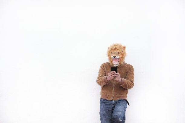 戴着咆哮狮子面具的男人在用手机图片下载