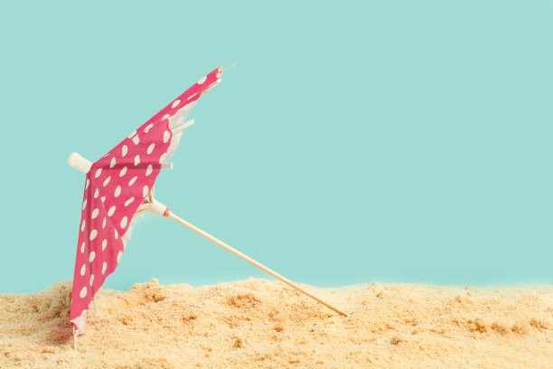 一把开在沙滩上的红白点伞图片下载