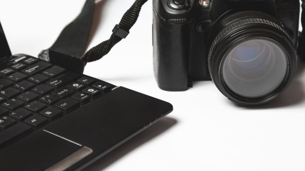 白色背景下的摄影师工作场所。现代笔记本电脑，数码相机。前视图。副本的空间。摄影师的设备。自由职业的概念图片下载