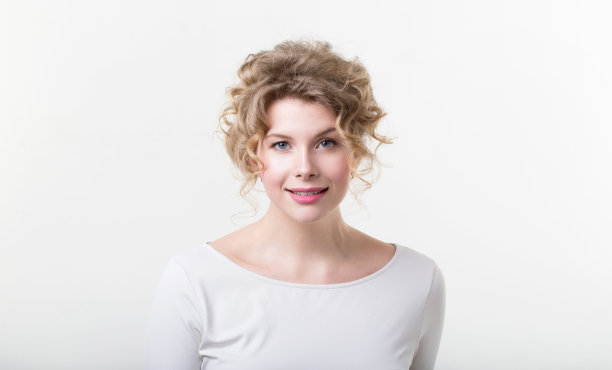 自然可爱的女人，一头卷发，白底上真诚的微笑。图片下载