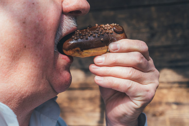 吃泡芙条的老人。享受退休生活的概念图片下载