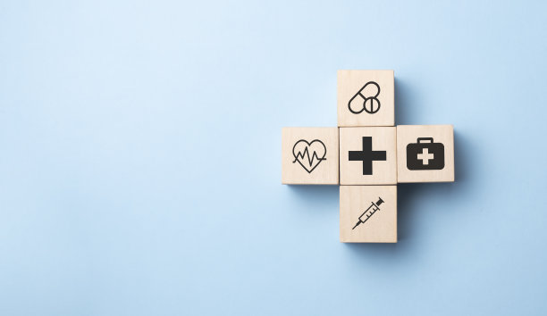 健康保险概念，人的手安排木质立方体堆叠与图标医疗保健在蓝色背景，复制空间。图片下载