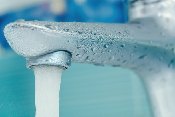 水滴落在浴室的水龙头上。宏观照片图片下载