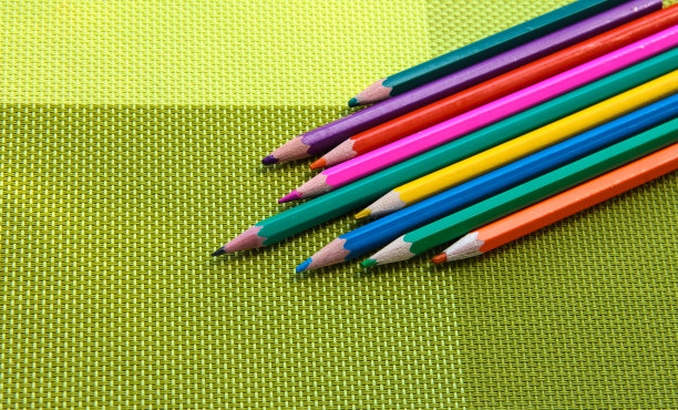 亮绿色背景上的彩色铅笔。图片下载