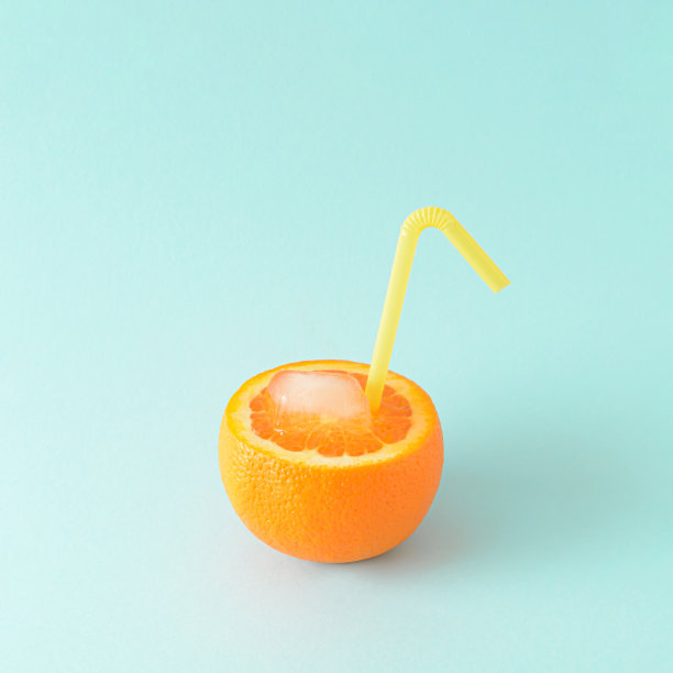 清爽的柑橘类水果，多汁的橘子与冰和别在蓝色的夏季背景上的饮用吸管。夏天汁的概念。图片下载