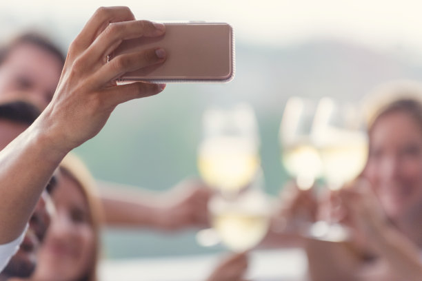 一群朋友在晚宴上用手机自拍。图片下载