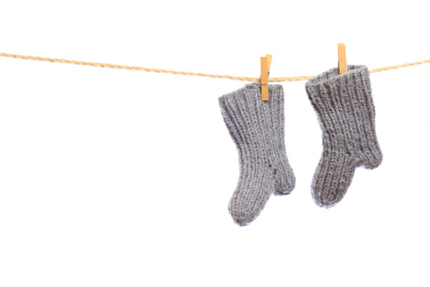 白色背景上晾衣绳上的婴儿衣服。针织袜子,图片图片下载