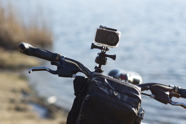 运动相机在自行车上与自行车背包在一个防水的情况下，以河的背景。图片下载