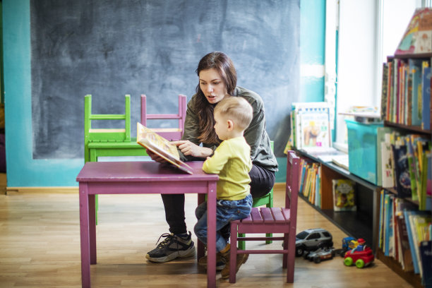 妈妈在图书馆给小男孩读书图片下载