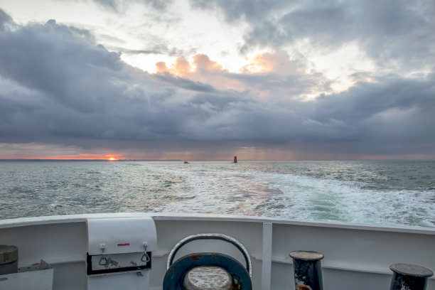 在宁静的海水和史诗般的清晨天空的帆船上，戏剧性的日出背景，浪漫的布列塔尼海岸线，菲尼斯特，法国图片下载