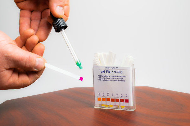ph值测试。碱性pH测试条。滴管的手图片下载