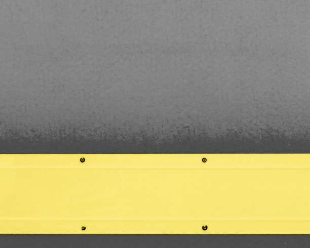 灰色背景上的黄色宽金属条纹。位于照片的底部。图片下载