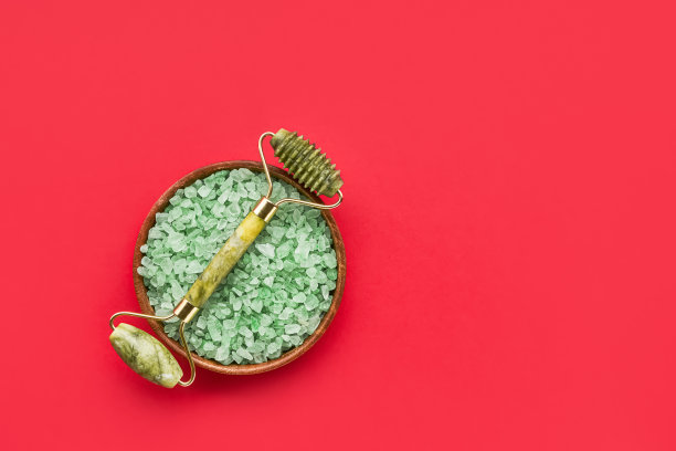 绿面玉辊和浴盐在明亮的红色背景上。水疗和健康理念。俯视图，复制空间图片下载