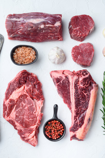 各种生牛肉肉排烧烤调料和器具，烟斗斧，t骨，棒牛排，肋眼和里脊切，在白色的石头背景，顶视图平lay图片下载