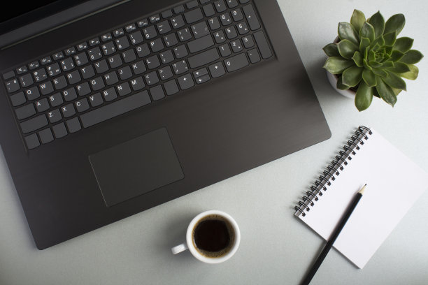 顶视图的办公桌与笔记本电脑，咖啡杯和仙人掌在灰色的背景。平整的办公桌。图片下载
