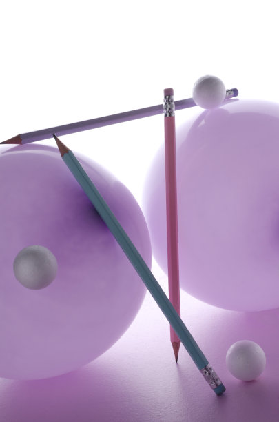 特写的紫色气球和彩色铅笔对白色粉红色的背景图片下载