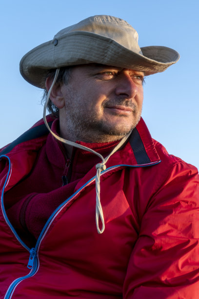 戴帽子的中年男人在日落时眺望远方图片下载