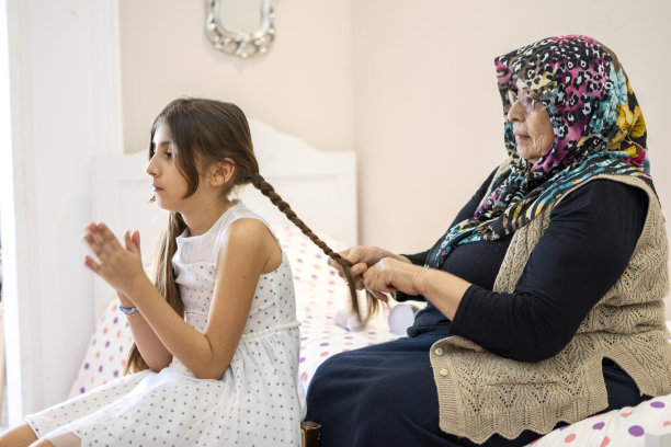 祖母给一个可爱的小女孩编辫子图片下载