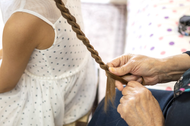 祖母给一个可爱的小女孩编辫子图片下载