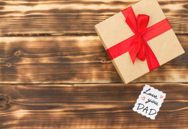 贺卡爱你爸爸和一个礼盒放在一个质朴的木制桌面上。平的。前视图。副本的空间。图片下载