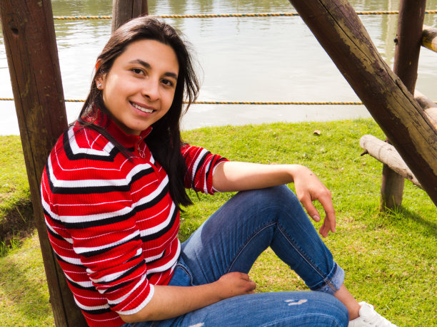 年轻女子在公园的湖边摆姿势图片下载