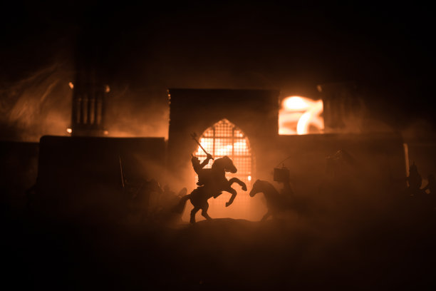 有骑兵和步兵的中世纪战斗场景。剪影的人物作为单独的对象，战斗之间的战士在日落雾蒙蒙的背景。图片下载