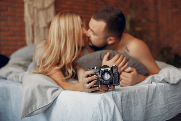 一对夫妇坐在房间的床上图片下载