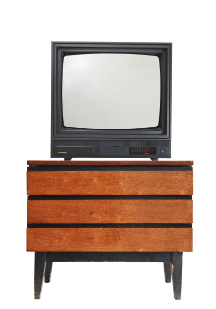 一台上世纪90、80年代的老式床头柜上放着一台白色背景的老式电视机。图片下载