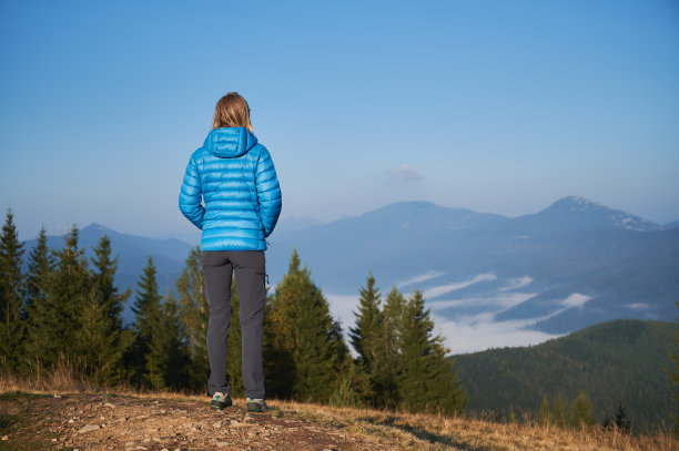 孤苦伶仃的金发年轻女子在山中行走。图片下载