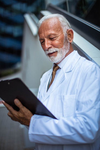 高级医生站在街上写文件。图片下载