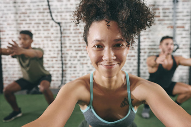 这是健身小组在健身房锻炼时做下蹲的照片图片下载