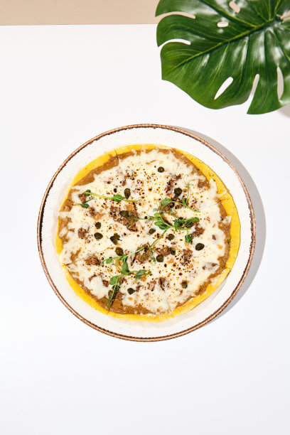 现代最小的烤箱披萨照片金枪鱼和山柑，伟大的设计为任何目的。披萨的海报。白色的桌子和米色的墙壁在阳光和棕榈叶阴影。夏日披萨概念。图片下载