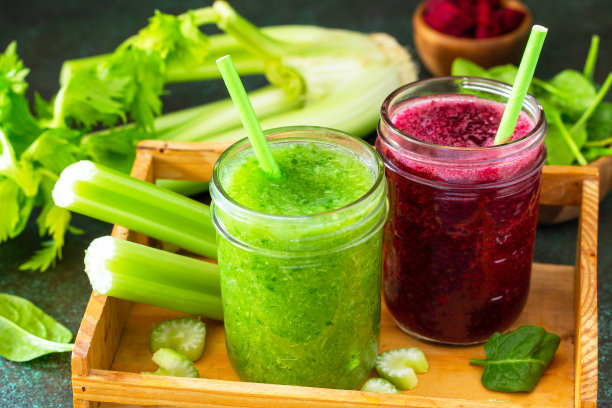 素食饮品，纯素饮食和营养，健康排毒的概念。甜菜冰沙和绿色冰沙，芹菜和菠菜在石头的背景。图片下载