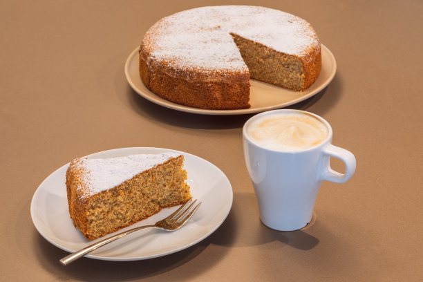 用杏仁和干面包(Antica torta alle mandorle e pane)和一杯卡布奇诺制作的老式蛋糕图片下载