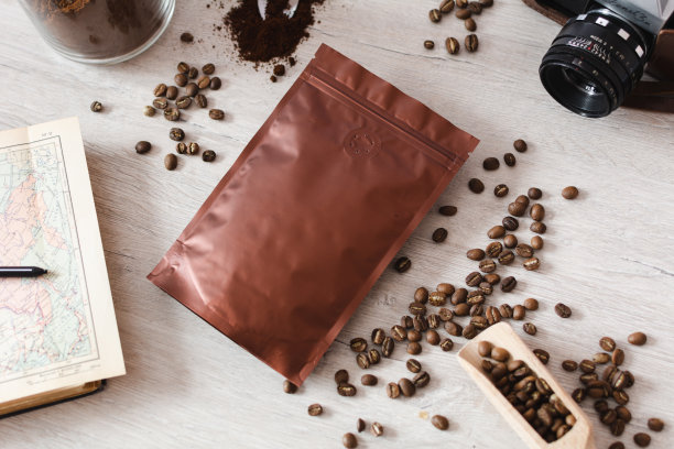 空白的咖啡包装放在木桌上，用咖啡种子，木勺放在木质背景上，咖啡包装模型用空白的空间展示您的品牌设计。图片下载
