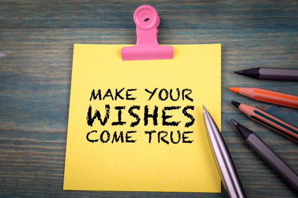 让你的愿望成真。笔记和办公用品在绿色的木制背景上图片下载