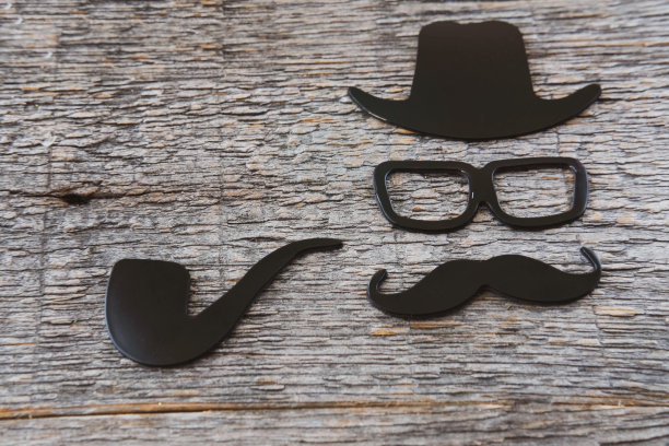 父亲节贴纸，帽子，眼镜，黑胡子，木制背景上的烟斗。潮人的对象。父亲节是一个节日图片下载