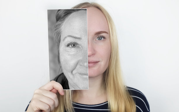 女孩把她老母亲的照片贴在脸上。衰老，遗传，家谱和年轻观念的丧失。与年龄相关的变化前后。的照片。图片下载