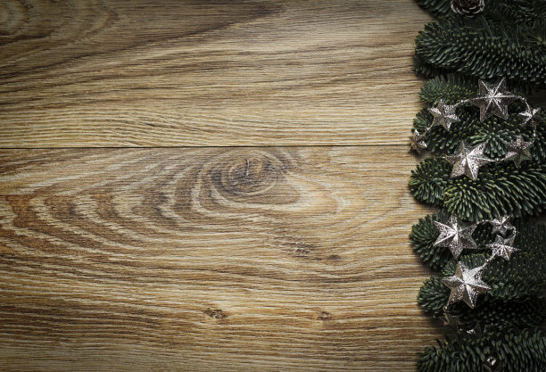 木背景与冷杉树枝和银色的星星。图片下载