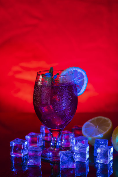 在一个迪斯科，酒吧或酒吧的混合红色和蓝色的光下清爽的鸡尾酒饮料。酒吧娱乐和社交生活的概念。垂直照片和选择焦点图片下载