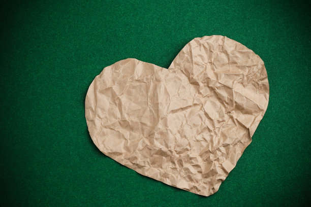皱巴巴的心在绿色背景和小插图上。图片下载