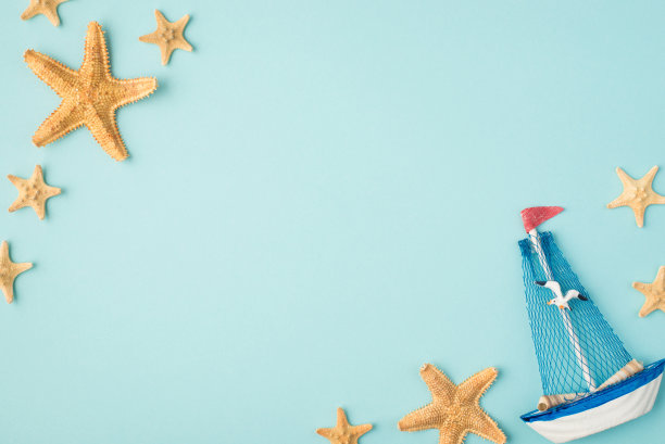 俯视图照片的船帆船玩具海鸥和海星在孤立的淡蓝色背景与copyspace在中间图片下载