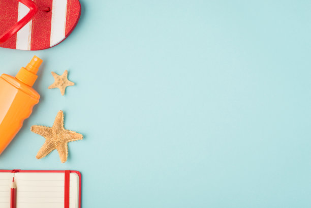 顶视图照片条纹人字拖橙色防晒霜瓶子海星红色铅笔和笔记本在孤立的淡蓝色背景与copyspace在右边图片下载
